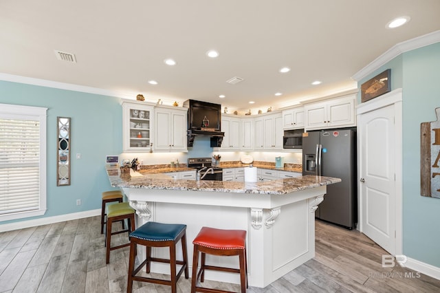 kitchen featuring white cabinets, light wood-type flooring, stainless steel appliances, and crown molding