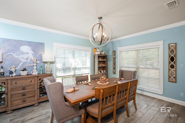 dining space with light hardwood / wood-style floors, a chandelier, and ornamental molding