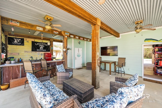 interior space featuring an outdoor living space, ceiling fan, and a bar