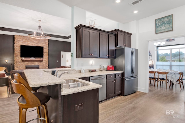 kitchen with stainless steel appliances, light hardwood / wood-style floors, sink, and dark brown cabinetry