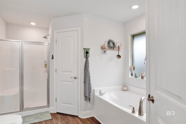 bathroom with wood-type flooring, plenty of natural light, and separate shower and tub