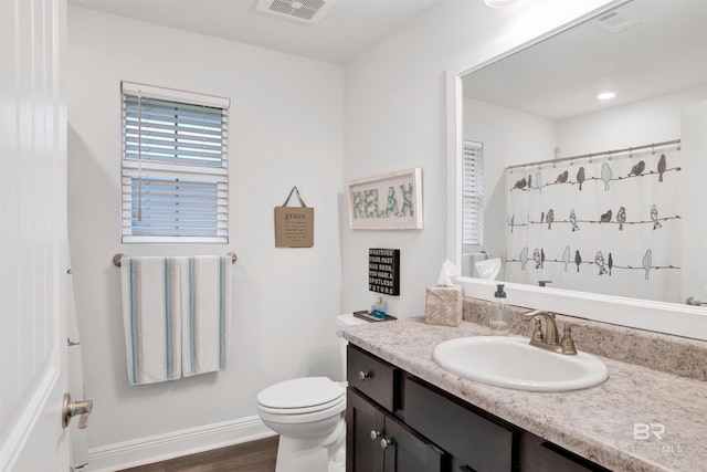 bathroom featuring wood-type flooring, toilet, vanity, and a shower with shower curtain