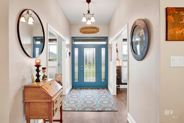 foyer entrance with wood-type flooring and a notable chandelier