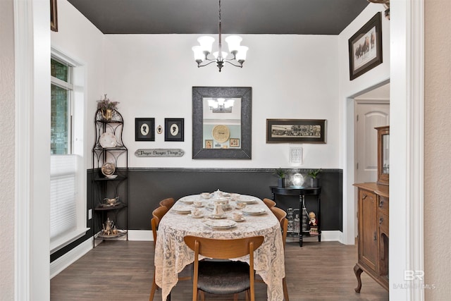 dining room featuring dark wood-type flooring and an inviting chandelier