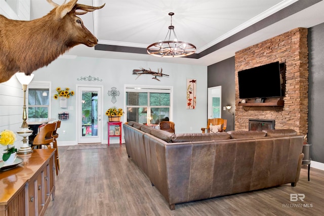 living room with hardwood / wood-style floors, a notable chandelier, a tray ceiling, and ornamental molding