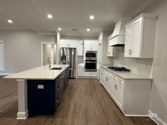 kitchen with stainless steel appliances, white cabinetry, sink, an island with sink, and dark wood-type flooring