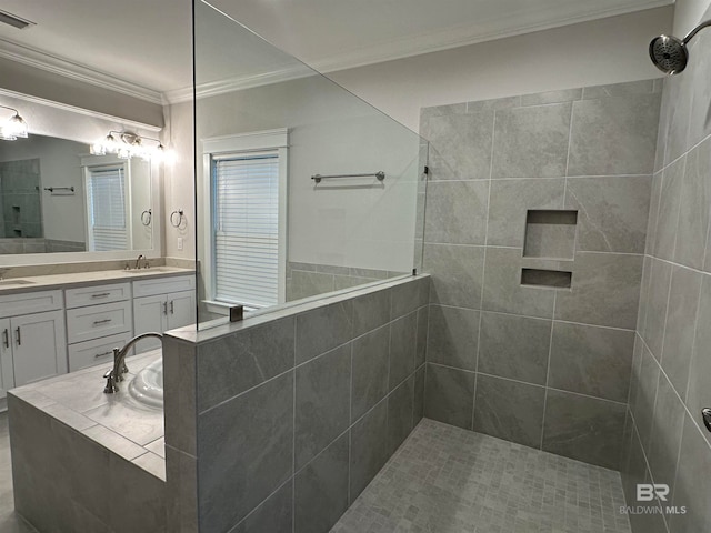 bathroom with vanity, a tile shower, and ornamental molding