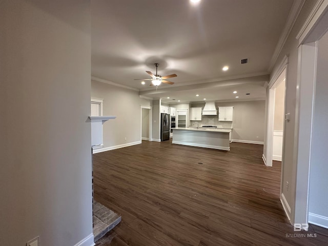 unfurnished living room with dark hardwood / wood-style flooring, sink, crown molding, and ceiling fan