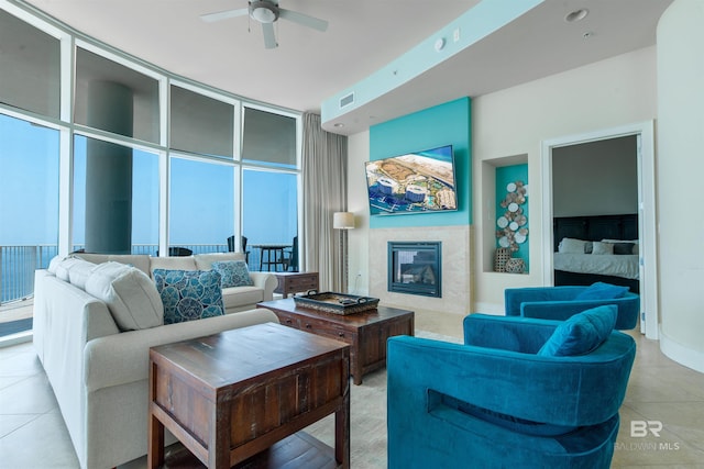 tiled living room with floor to ceiling windows and ceiling fan