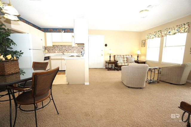 carpeted dining space with sink