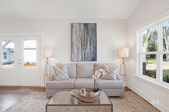 living room featuring light wood-type flooring, vaulted ceiling, and french doors