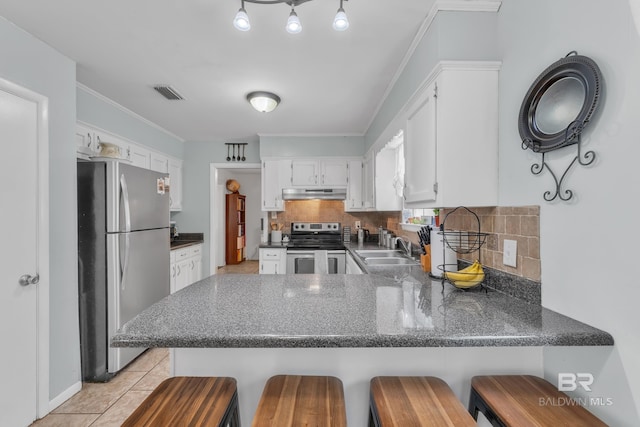 224 Cache Cir, Chickasaw, AL 36611 - kitchen featuring appliances with stainless steel finishes, under cabinet range hood, a peninsula, a sink, and white cabinets