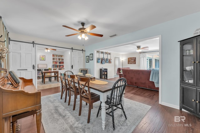 224 Cache Cir, Chickasaw, AL 36611 - dining room with a barn door, a ceiling fan, dark wood-style floors, and baseboards
