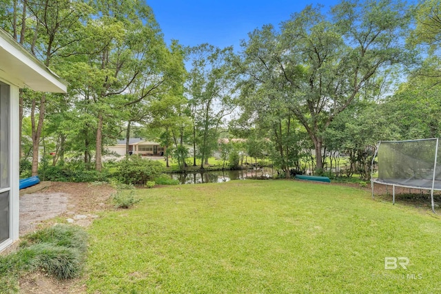224 Cache Cir, Chickasaw, AL 36611 - view of green lawn featuring a trampoline and a water view
