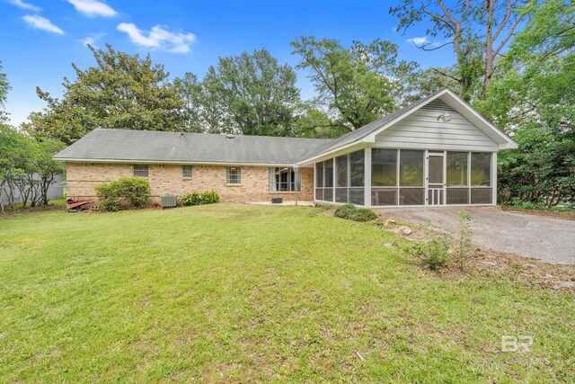 224 Cache Cir, Chickasaw, AL 36611 - rear view of property featuring a sunroom, a lawn, brick siding, and central AC unit