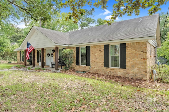 224 Cache Cir, Chickasaw, AL 36611 - ranch-style home featuring brick siding, a porch, a shingled roof, and a front yard