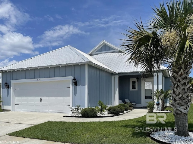 4844 E Cypress Loop, Orange Beach, AL 36561 - view of front of house featuring board and batten siding, an attached garage, concrete driveway, metal roof, and a front lawn