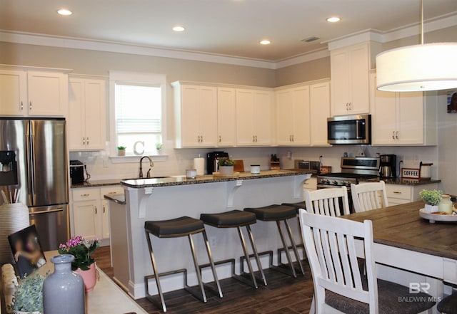 4844 E Cypress Loop, Orange Beach, AL 36561 - kitchen featuring appliances with stainless steel finishes, dark wood-style floors, a sink, white cabinets, and backsplash