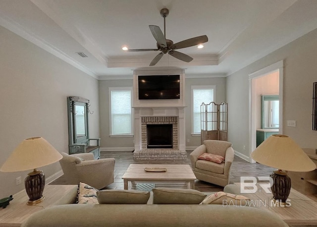 4844 E Cypress Loop, Orange Beach, AL 36561 - living room featuring a raised ceiling, a brick fireplace, wood finished floors, crown molding, and recessed lighting