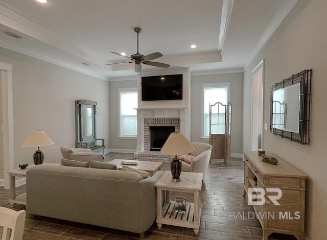 4844 E Cypress Loop, Orange Beach, AL 36561 - living area featuring a tray ceiling, crown molding, a brick fireplace, ceiling fan, and recessed lighting