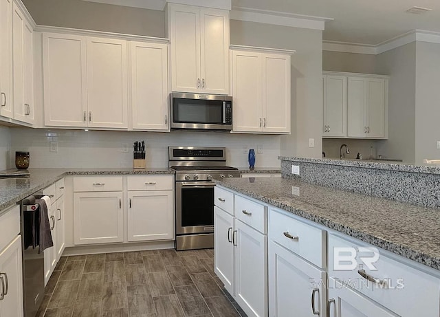 4844 E Cypress Loop, Orange Beach, AL 36561 - kitchen featuring stainless steel appliances, white cabinetry, ornamental molding, and light stone countertops