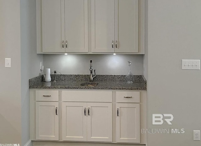 4844 E Cypress Loop, Orange Beach, AL 36561 - kitchen featuring a sink, dark stone counters, and white cabinets