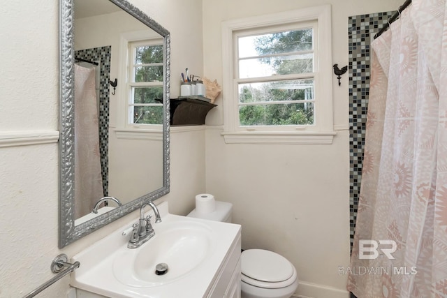 full bathroom featuring a shower with shower curtain, vanity, and toilet