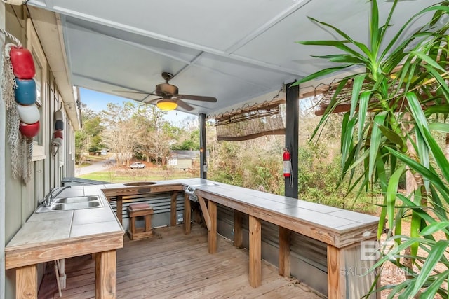 wooden deck with ceiling fan and a sink