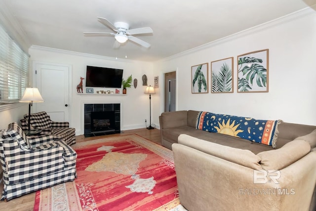 living area with a fireplace, ornamental molding, and wood finished floors