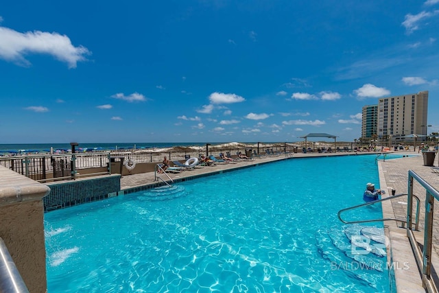 view of swimming pool with a water view and pool water feature