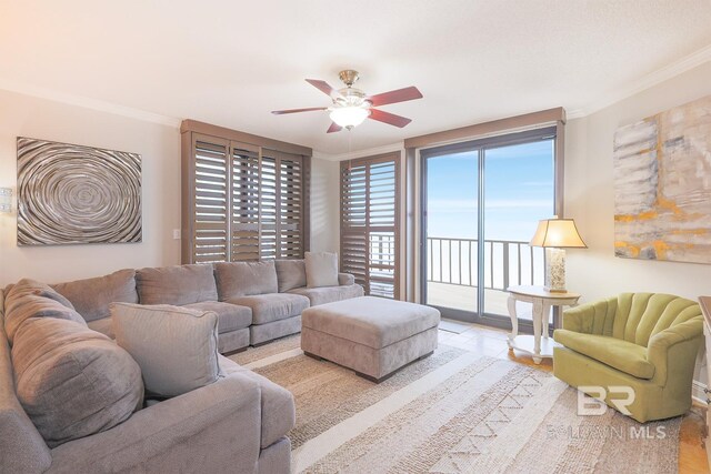 tiled living room with ornamental molding and ceiling fan