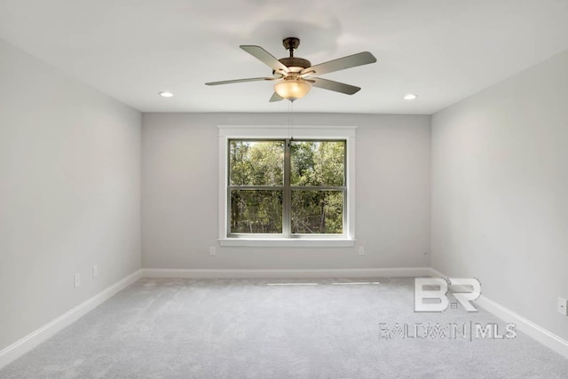 spare room featuring light carpet and ceiling fan