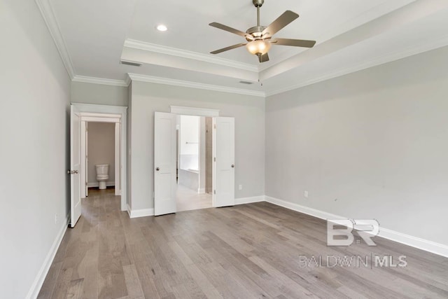 unfurnished room with ceiling fan, light hardwood / wood-style floors, ornamental molding, and a tray ceiling