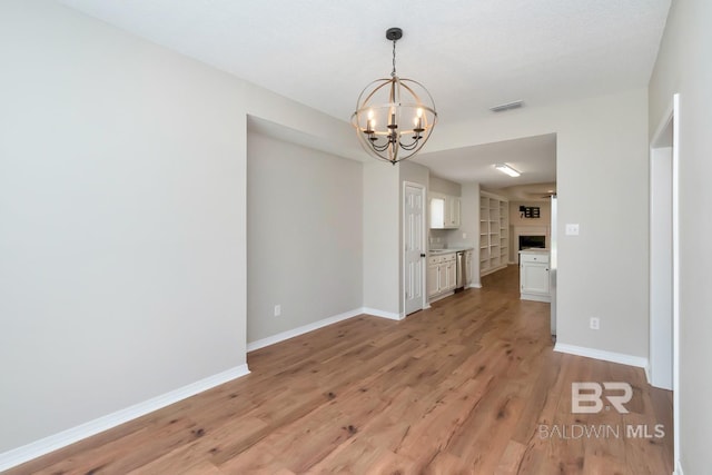 unfurnished dining area with light wood finished floors, baseboards, visible vents, and a fireplace