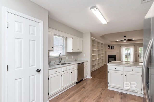 kitchen with white cabinetry, light countertops, a sink, ceiling fan, and appliances with stainless steel finishes