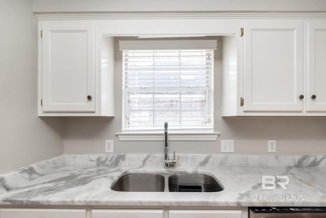 kitchen with white cabinetry, a sink, light stone counters, and dishwasher