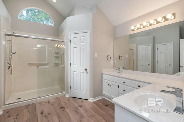 bathroom featuring an enclosed shower, vanity, wood-type flooring, and vaulted ceiling