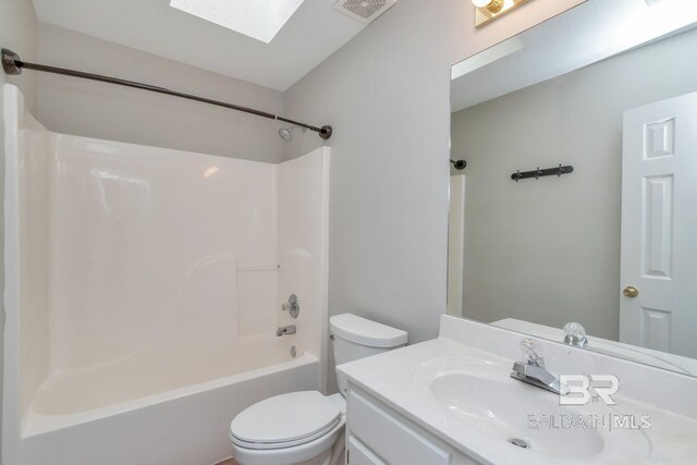 full bathroom featuring a skylight, vanity, shower / bathtub combination, and toilet