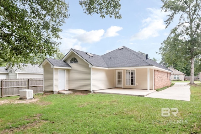 rear view of property featuring fence, a shingled roof, a patio area, and a yard