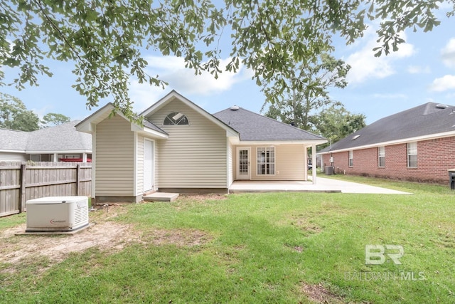 rear view of house with a patio, fence, roof with shingles, and a yard