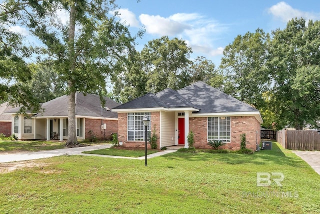 view of front of home featuring a front lawn, fence, and brick siding