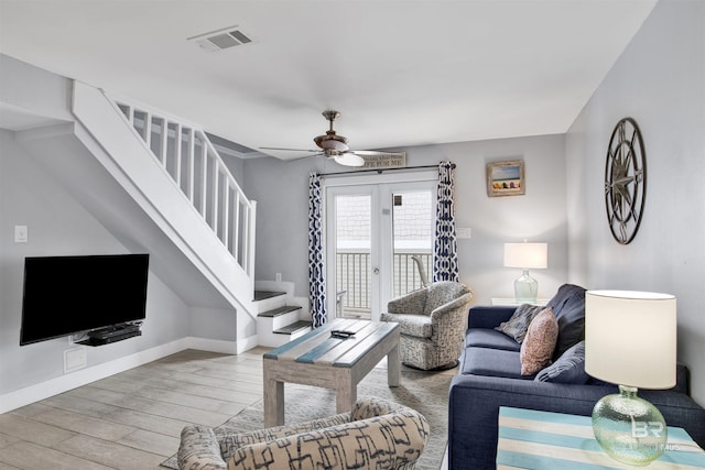 living room featuring ceiling fan, light hardwood / wood-style floors, and french doors