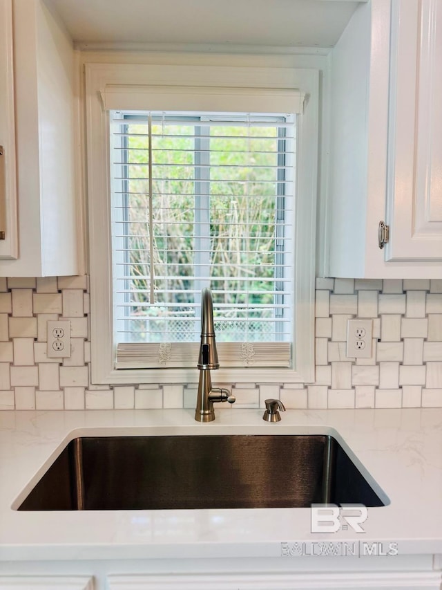 2663 Demetropolis Rd, Mobile, AL 36693 - kitchen view of backsplash, light stone countertops, and white cabinets