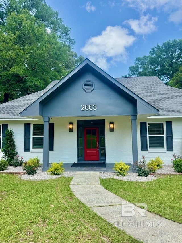 2663 Demetropolis Rd, Mobile, AL 36693 - view of front of home featuring a shingled roof, a front lawn, brick siding, and covered porch
