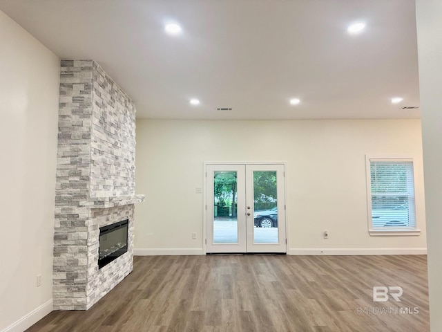 2663 Demetropolis Rd, Mobile, AL 36693 - unfurnished living room with wood finished floors, a stone fireplace, french doors, and recessed lighting