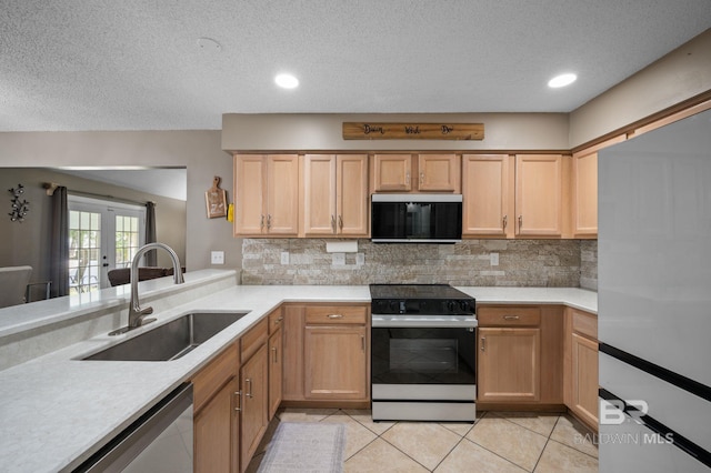 kitchen with range with electric stovetop, a sink, backsplash, light countertops, and a textured ceiling