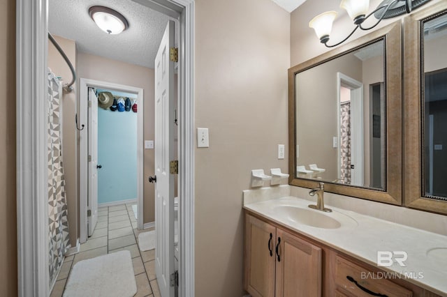full bathroom with vanity, a textured ceiling, tile patterned floors, and curtained shower