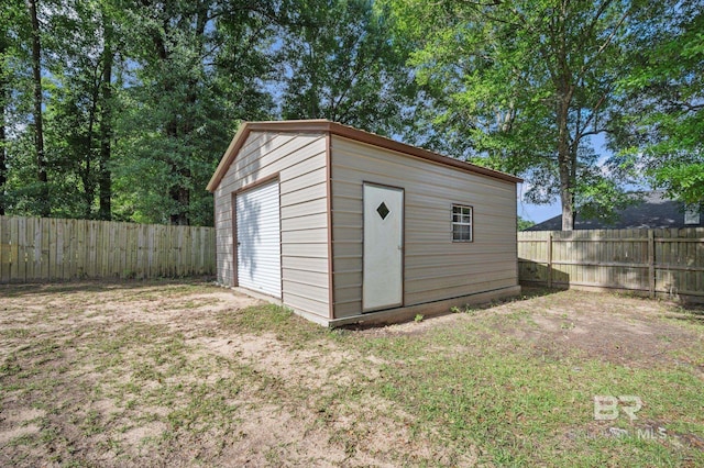 view of outbuilding with a fenced backyard and an outbuilding