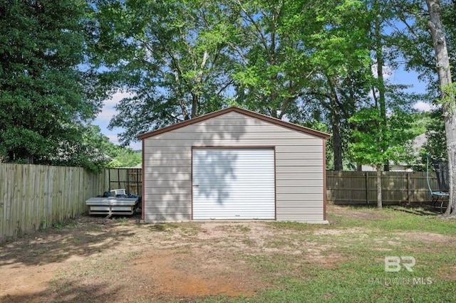 view of outbuilding with a trampoline and an outbuilding