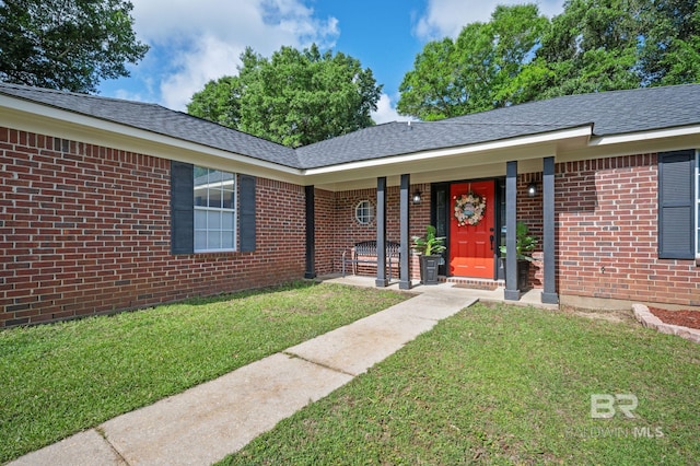property entrance with a yard, brick siding, covered porch, and roof with shingles